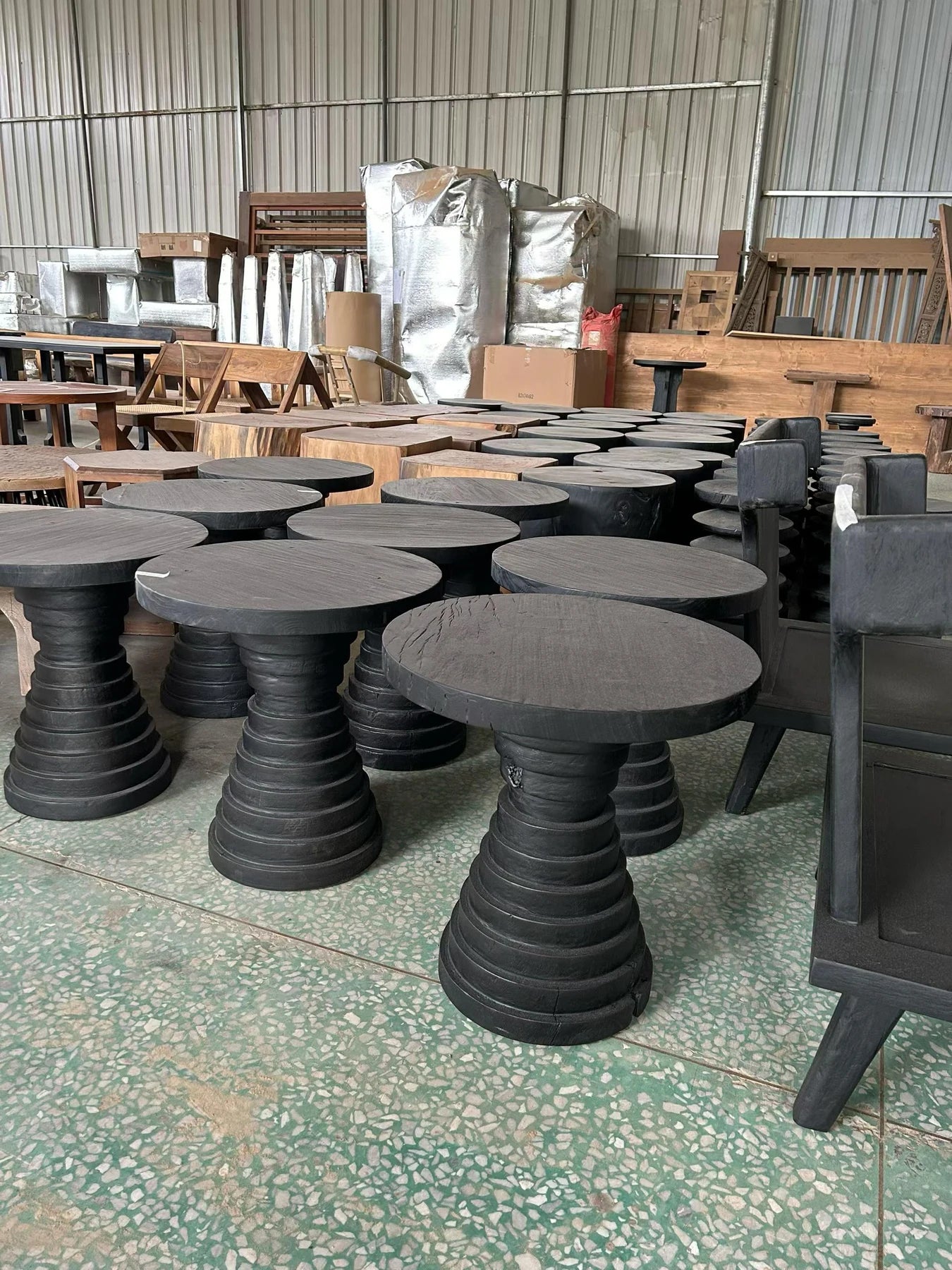 A real workshop batch of dark timber side tables prepared for project checks
