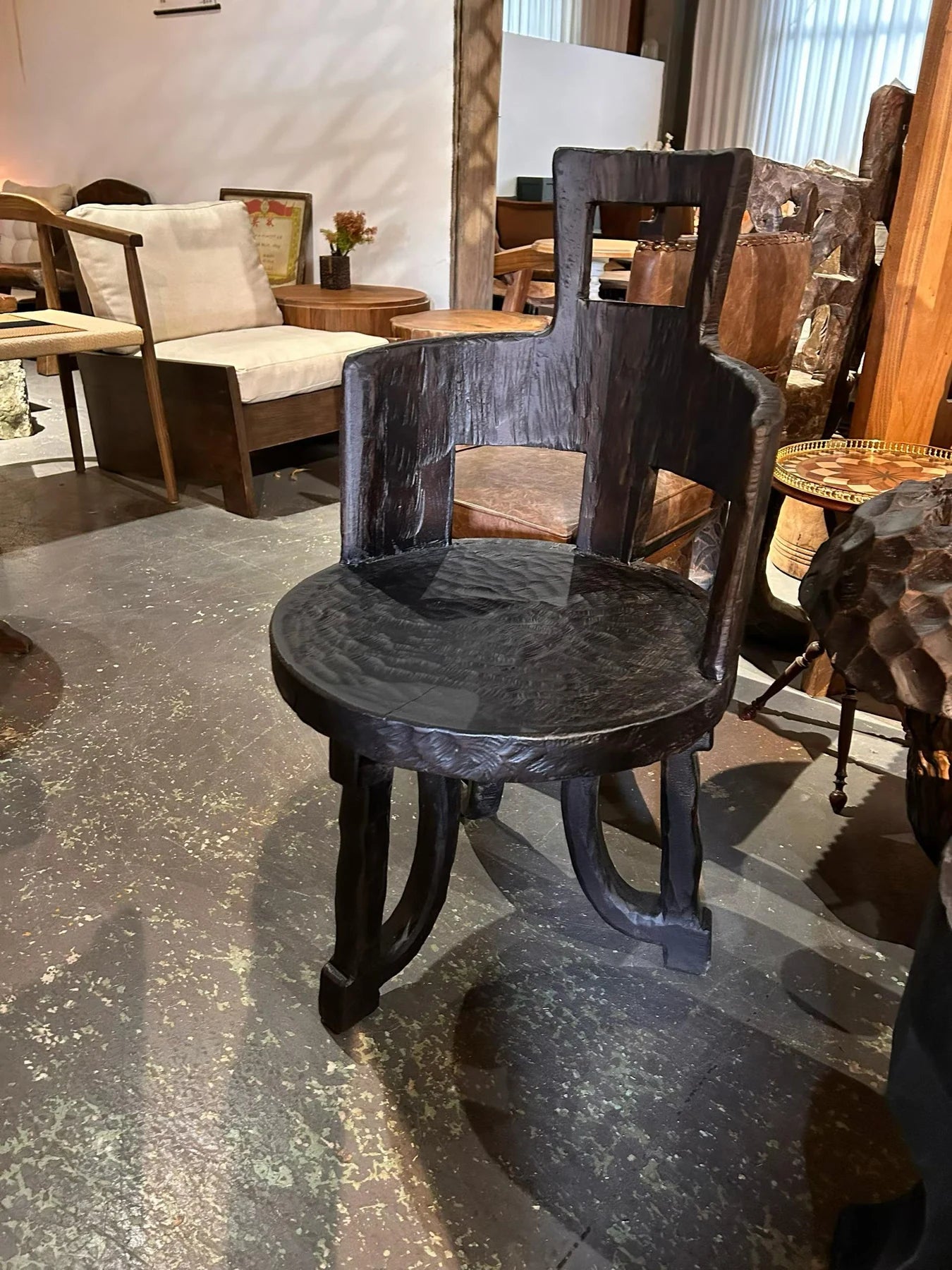 A finished sculptural timber chair photographed at the manufacturing partner