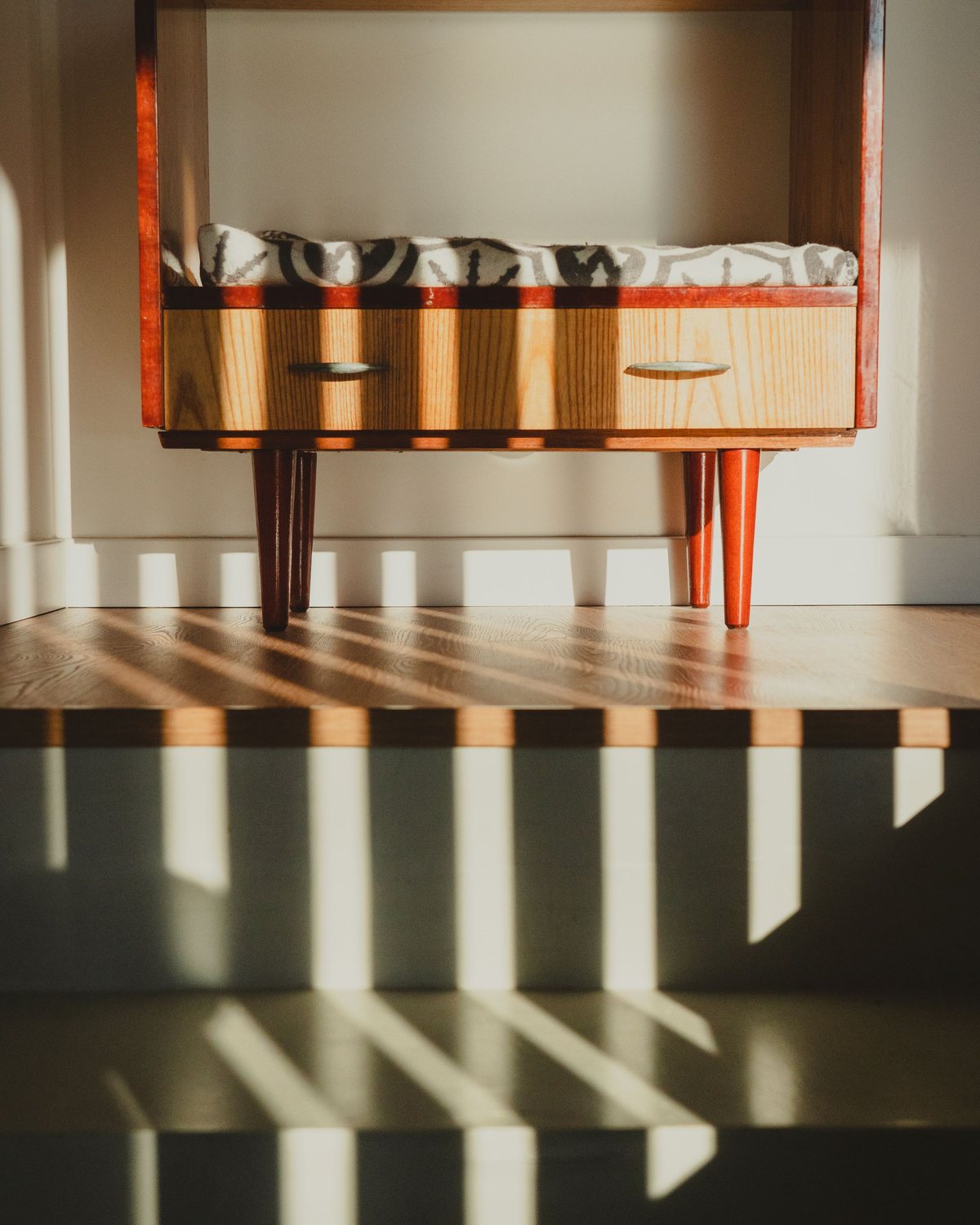 Warm cabinet detail with sunlight and deep wood tone