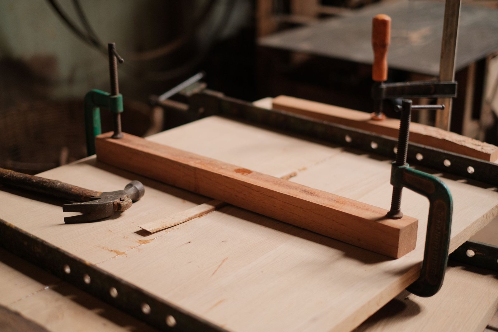A timber furniture frame held in clamps during a workshop check