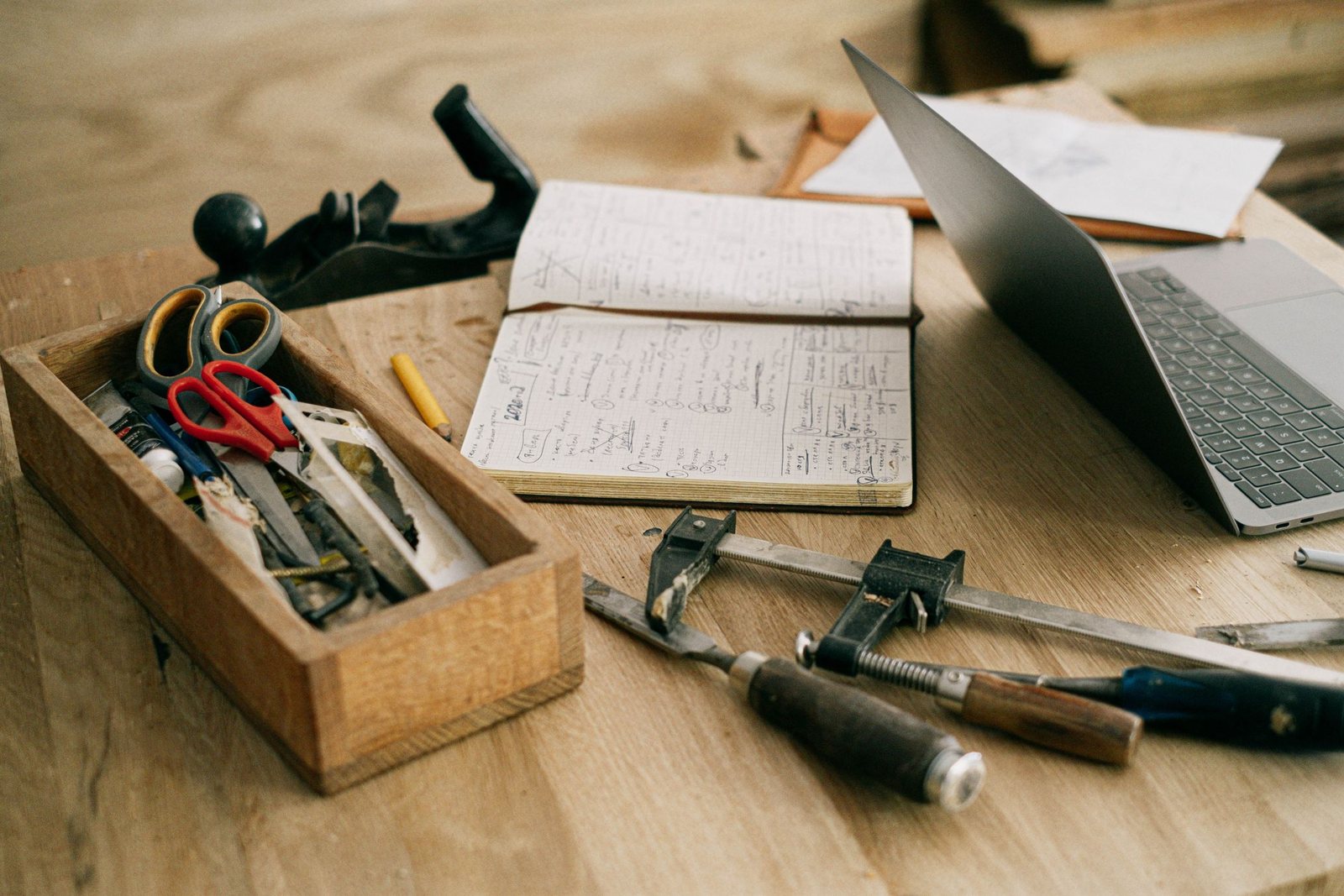 Woodworking tools and notes laid out on a work table
