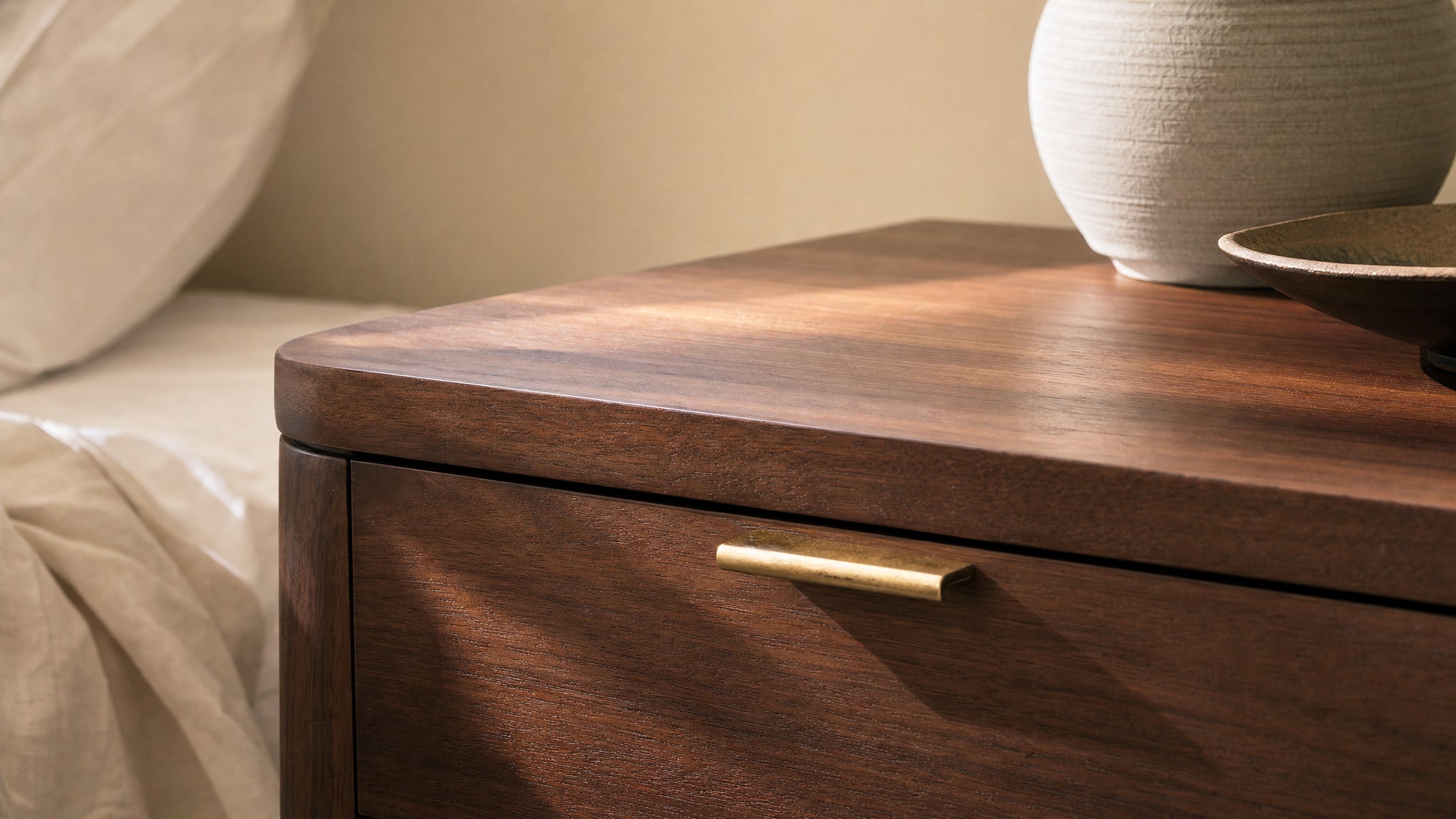 Close detail of warm wood furniture grain and brass handle